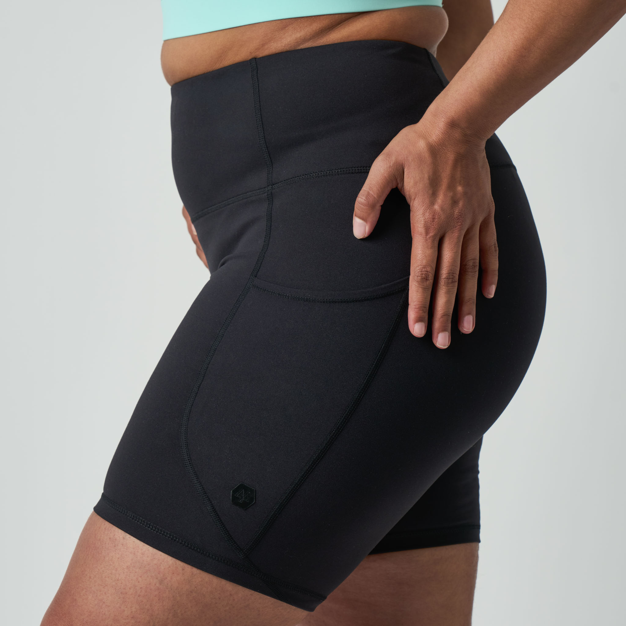 Person wearing black athletic shorts on a light gray background