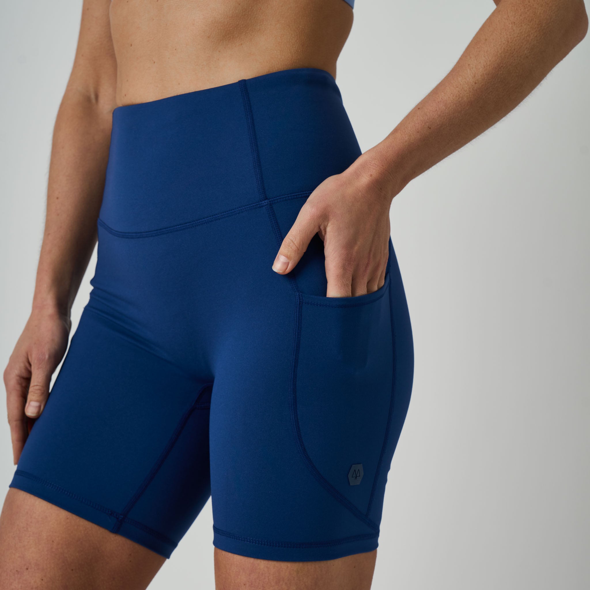 Blue athletic shorts worn by a person on a plain background