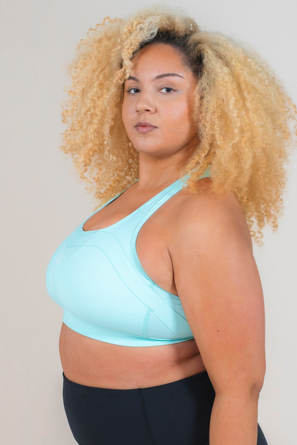 Woman standing side on wearing MAAREE Empower Sports Bra in Spearmint Green colour