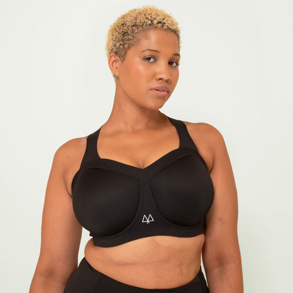 Woman wearing a black sports bra and leggings on a white background