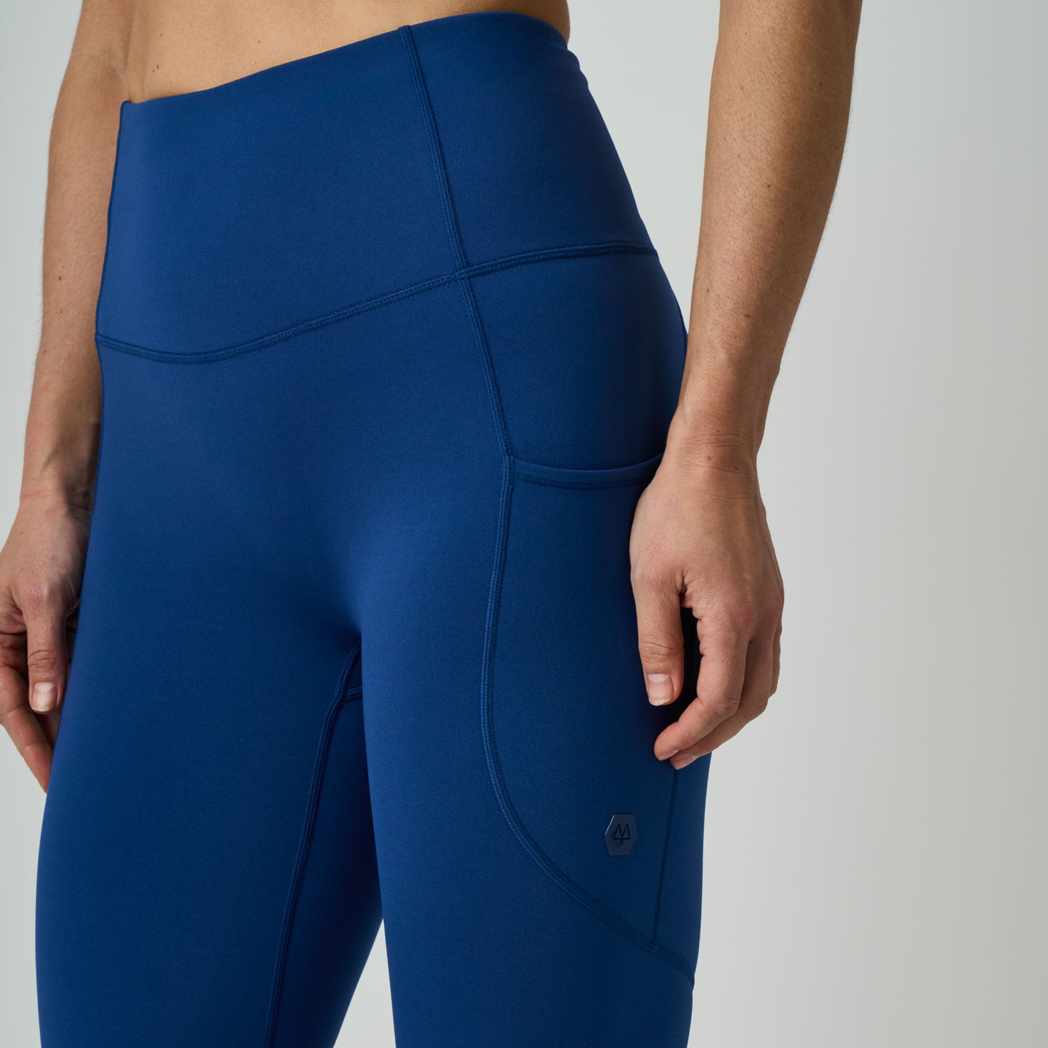 Blue athletic leggings worn by a person on a light gray background